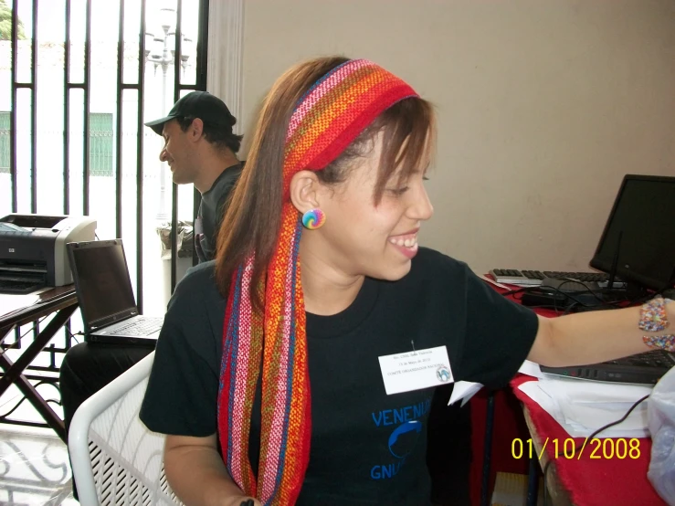 a woman with multicolored ids standing in front of a computer