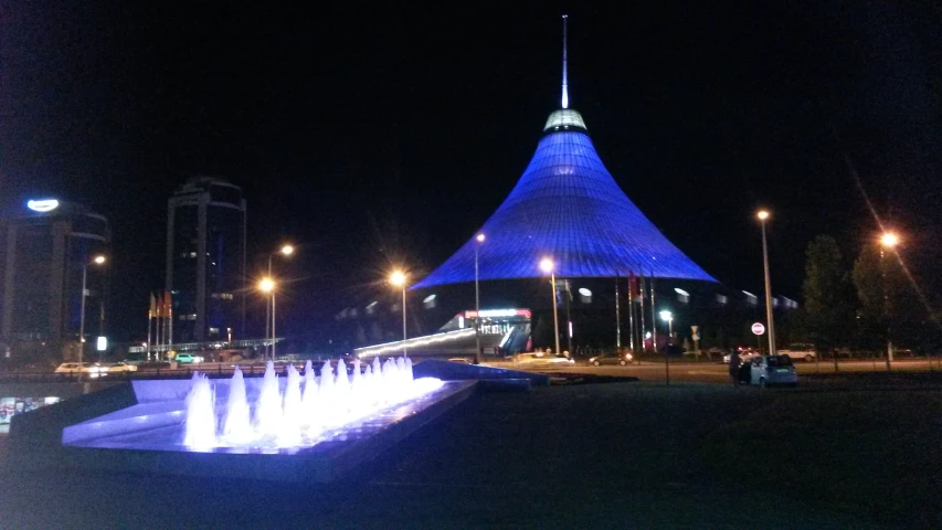 water fountains at the base of a building near street lights