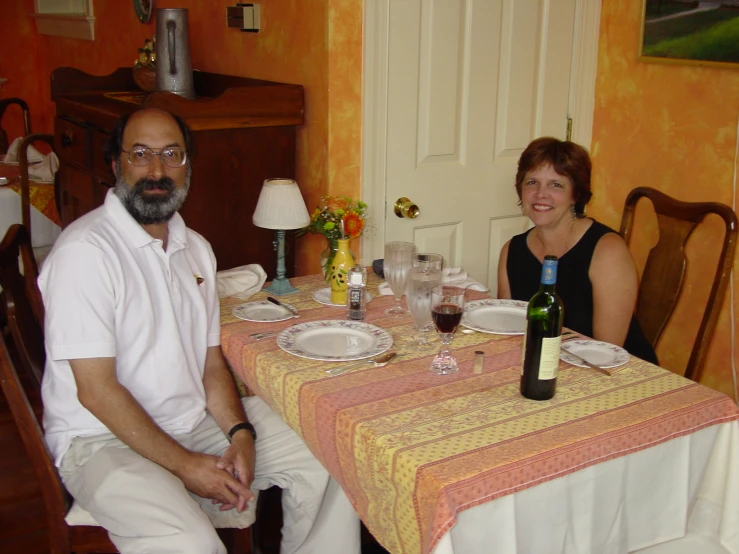 man and woman sitting next to each other at a dinner table