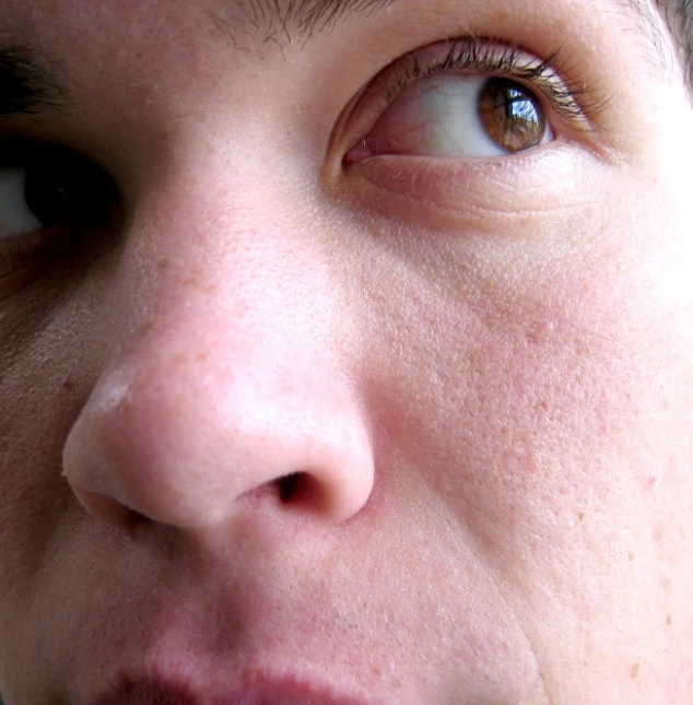 a woman with brown eyes is brushing her teeth