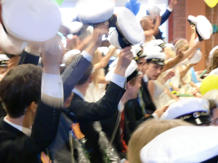 crowd of people dressed in white hats and party dresses