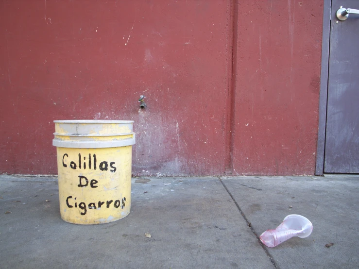 a small bucket sitting in front of a large wall