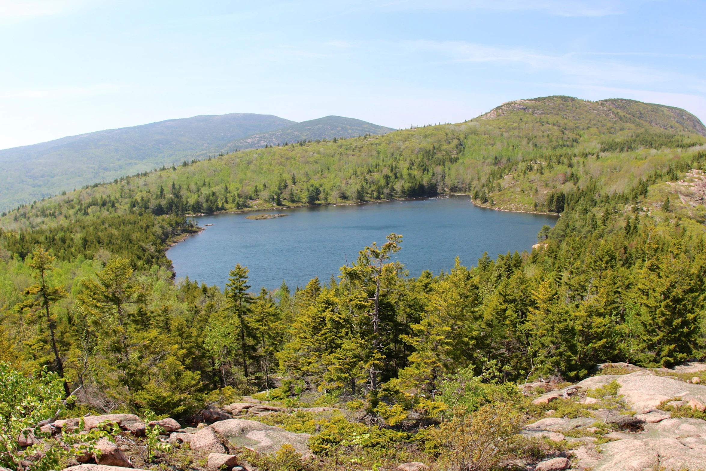 a lake nestled among the trees near a mountain