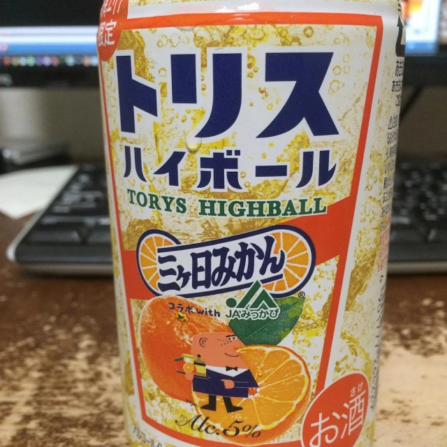 a can of orange fruit soda sits on a table
