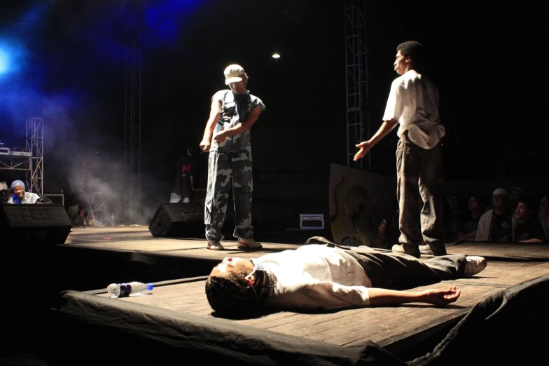 a person laying on the stage in front of other people