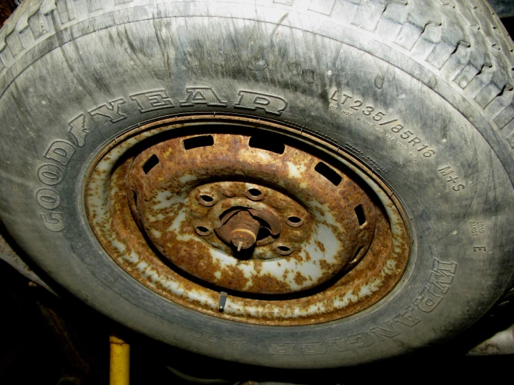 a rusted wheel on top of a rusted tire