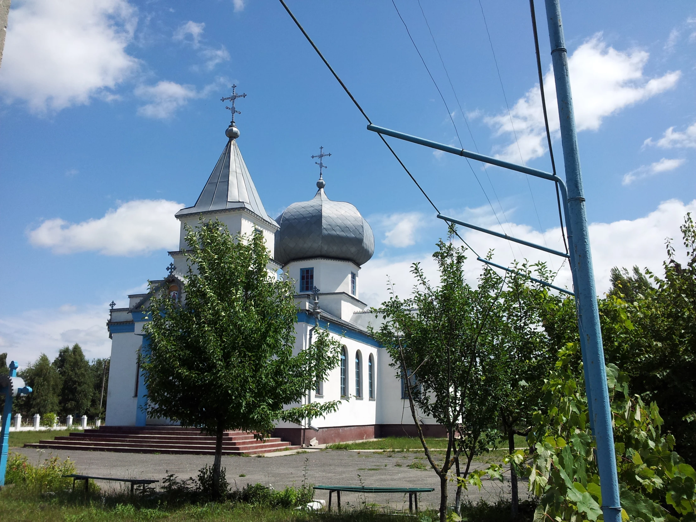 a church with a white tower and blue sky