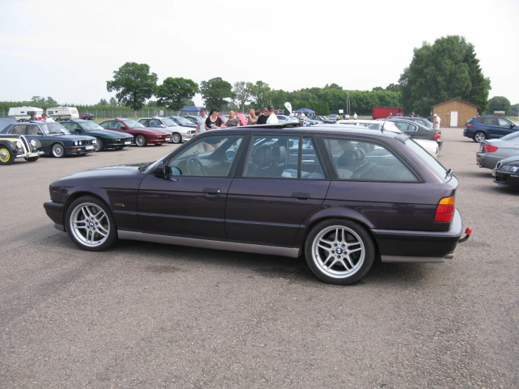 there is a black bmw parked next to several other cars