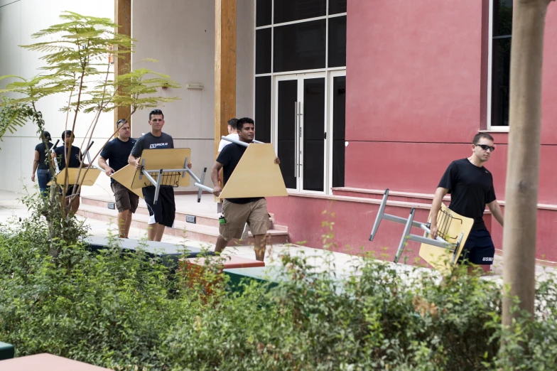 there are many people carrying items outside of a building