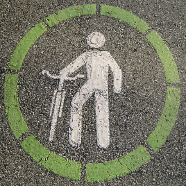 a sign painted on the pavement with a person holding a baseball bat