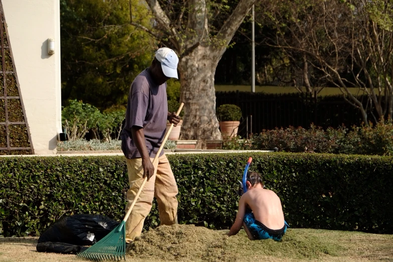 the two men are laying on the ground in the yard