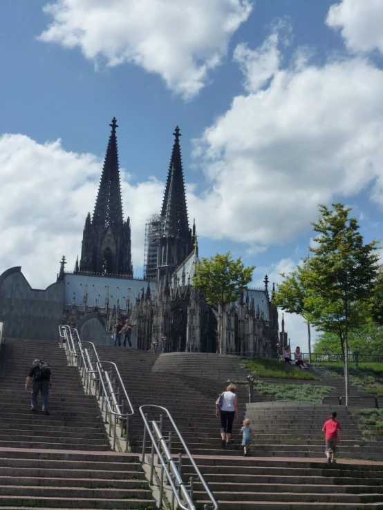 tourists walk up the stairs toward cathedral in france