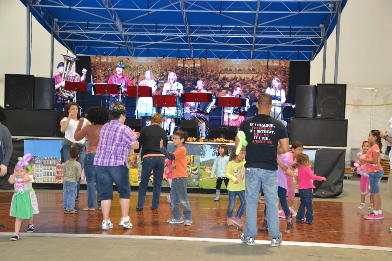 many children dance around on the floor while adults perform