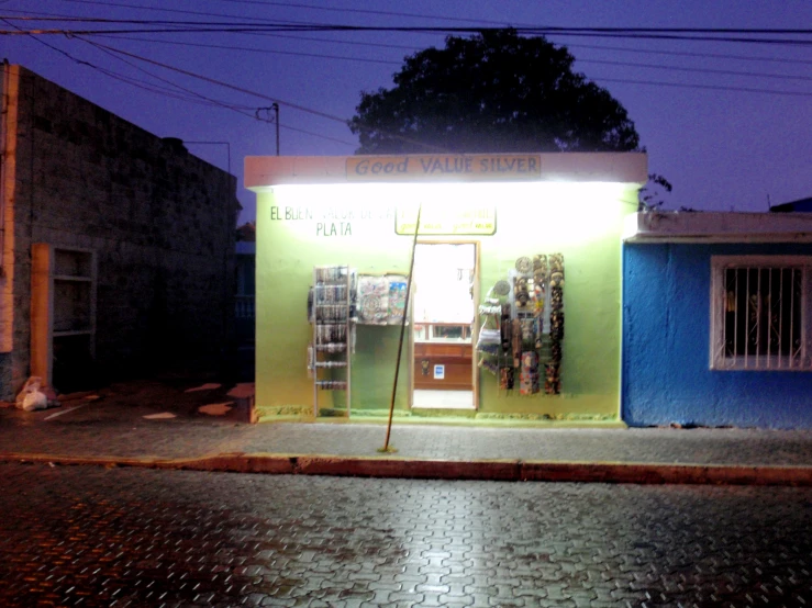 there is a small store in the middle of the street at night