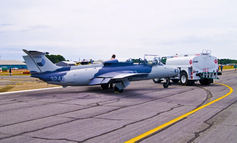 a plane with a military themed painted on it's sides and a fire truck near by