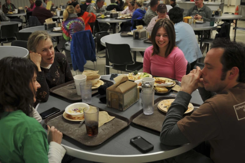 some people sitting at a table with food and drinks