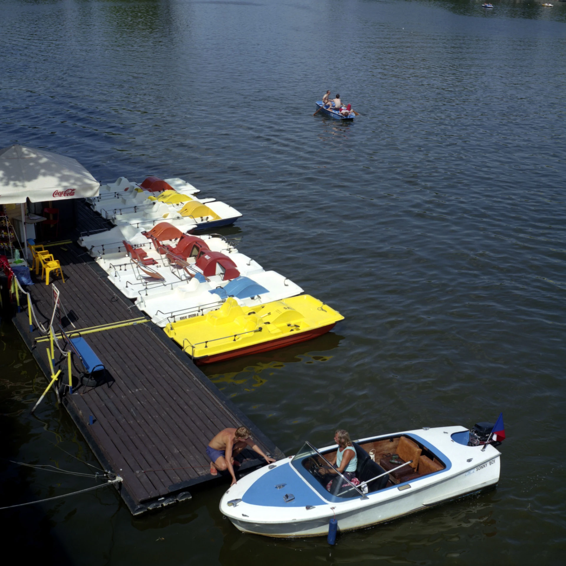 several small boats tied to the dock with passengers on the deck