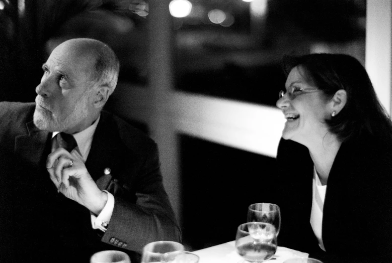 an older couple sitting at a table talking