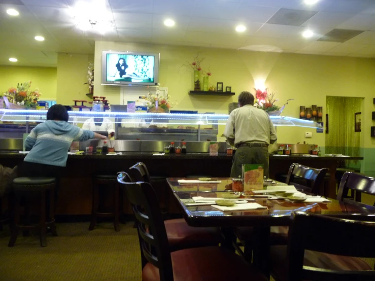 a couple of people in a restaurant that has tables