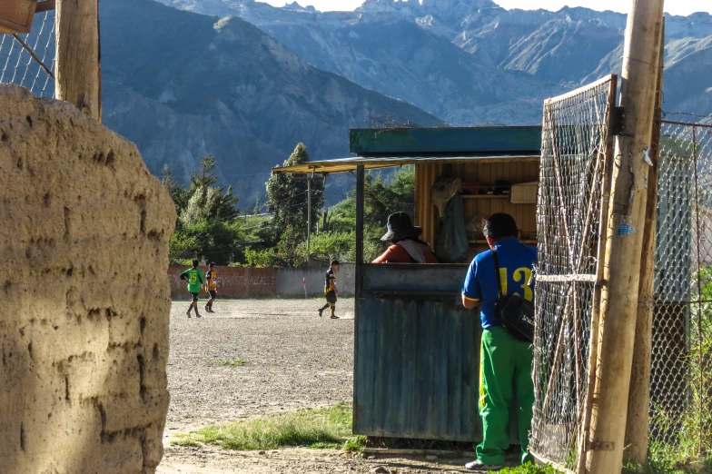 people on a soccer field near the mountains