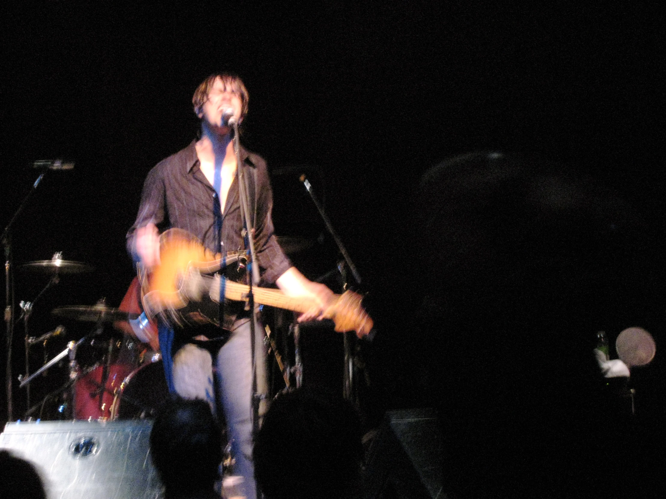 a man in a tie is on stage with guitar