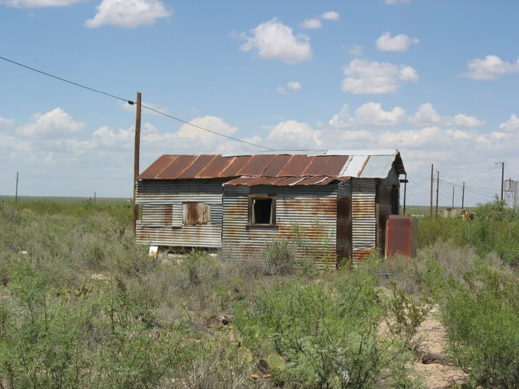 a run down building in the middle of an open field