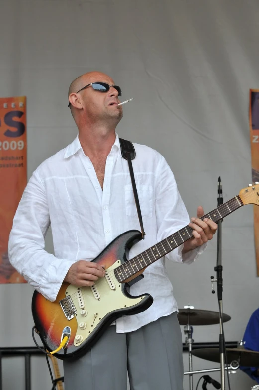 the man is playing his guitar on stage