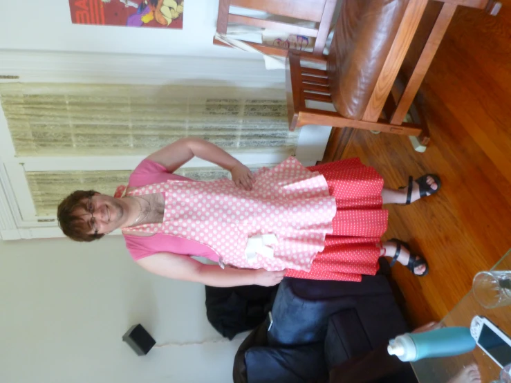 a woman standing in a living room wearing pink