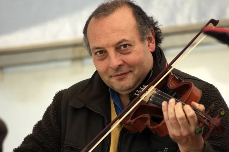 a man holding an instrument with two strings