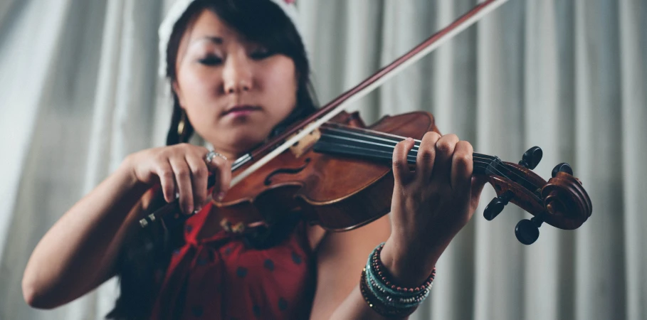 woman playing the violin and staring intently in unison