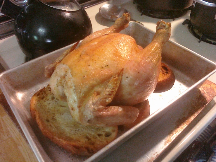 a chicken in a pan on top of a stove