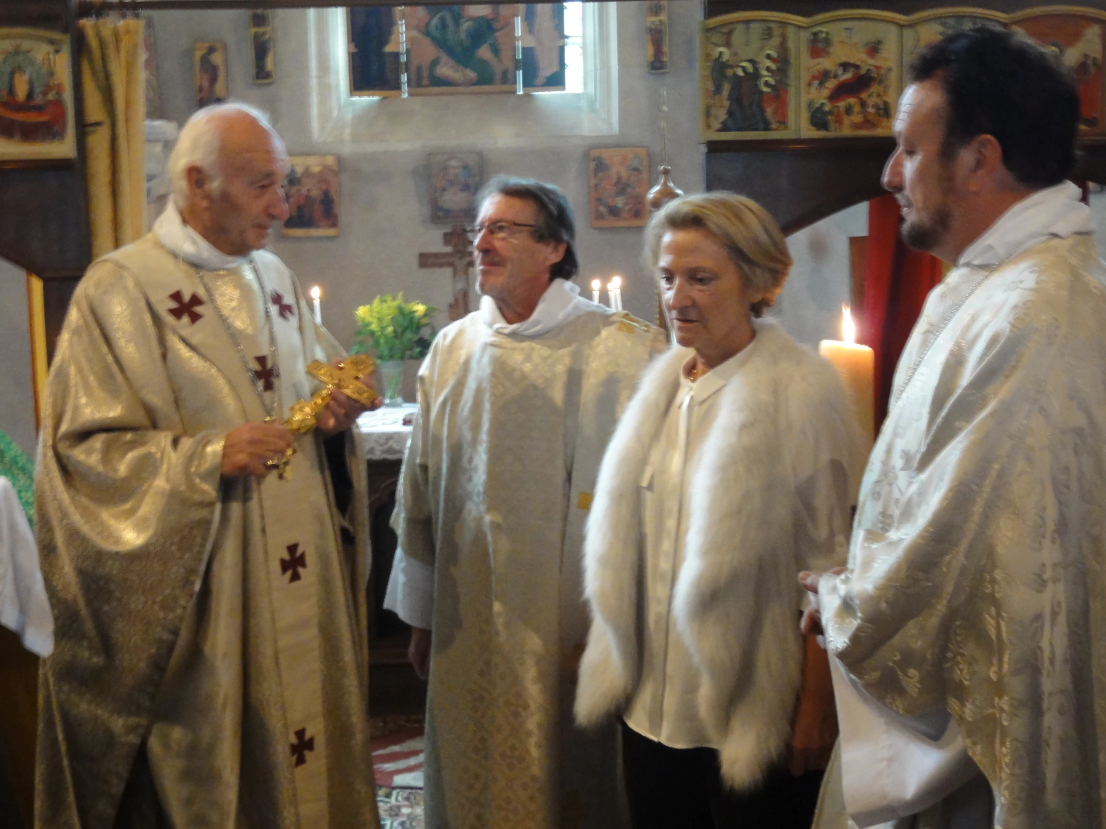 priest with a woman, two men and one woman looking towards the camera