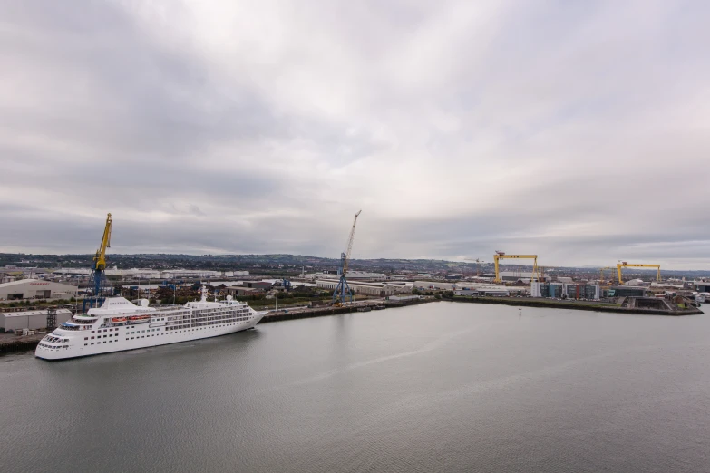 a white ship in the water next to some buildings