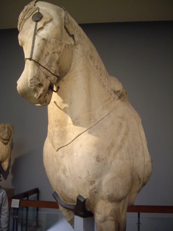 a statue of a horse stands next to a man