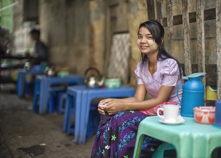 a woman sitting at a table next to a blue table