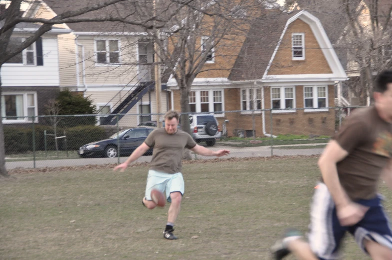 a man kicking around a frisbee on top of a field