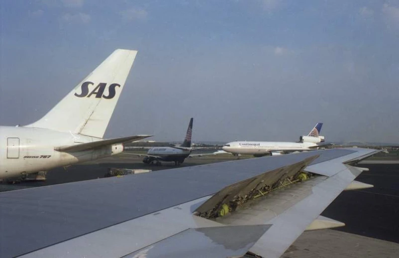 several commercial jetliners are lined up on the runway