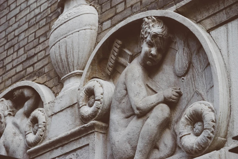 an old statue that is on the side of a building