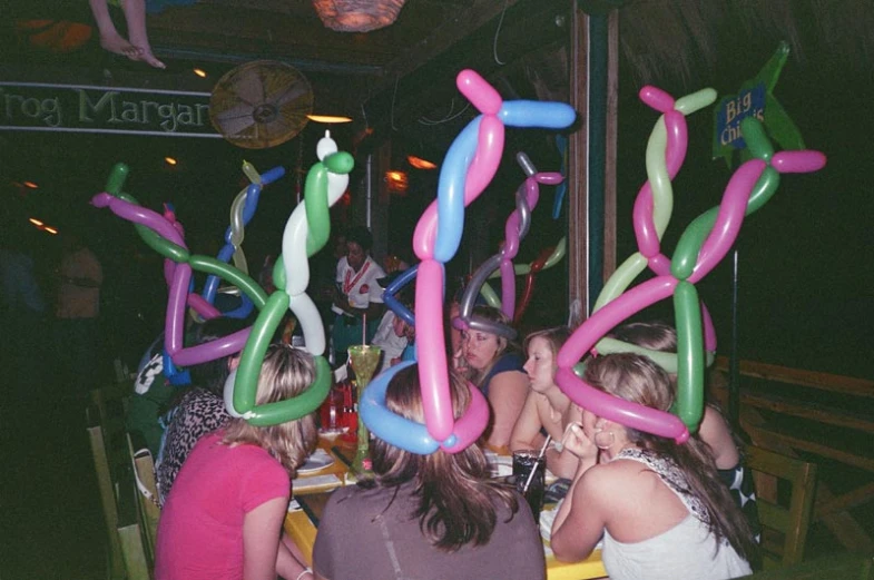 a party with balloons and streamers in the shape of women