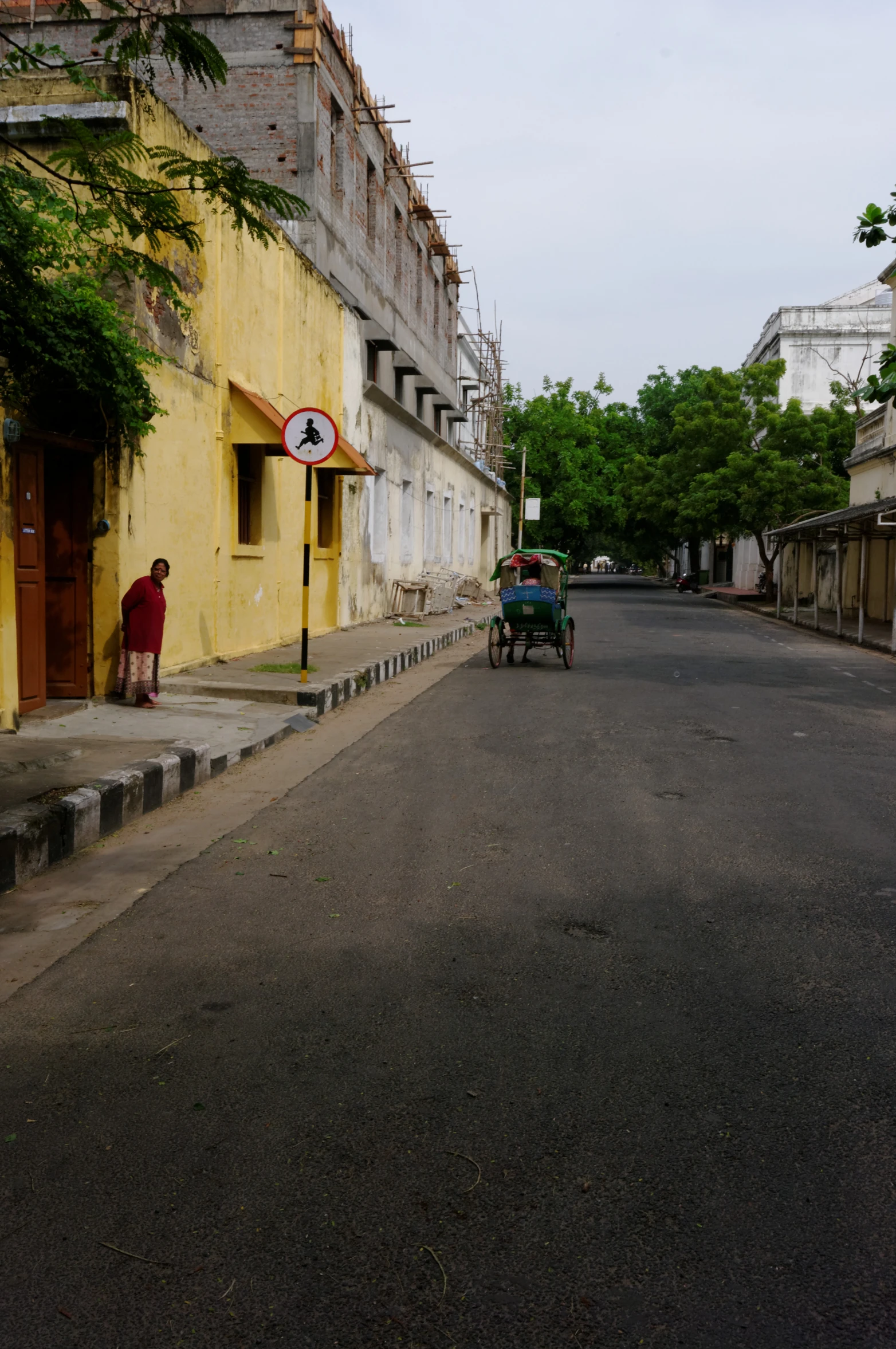 a street with buildings and a person on a horse drawn cart