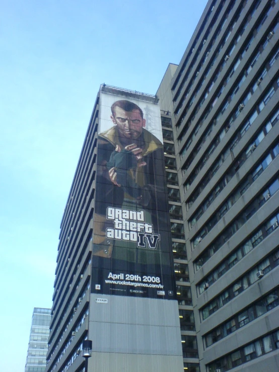 the back side of a giant building shows a giant movie billboard