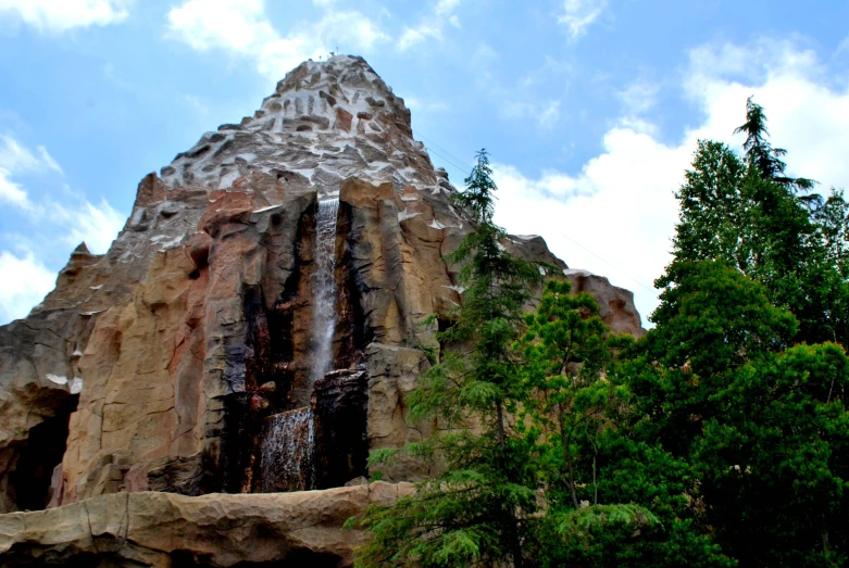 a large water fall is surrounded by trees