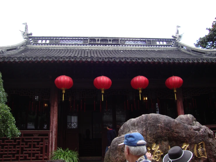 asian style building with lanterns and statues by the entry