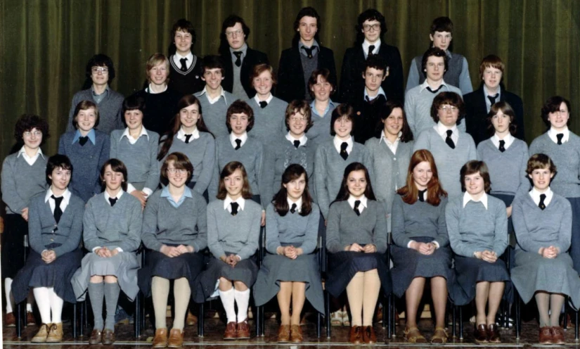 a group of young men and women wearing suits, ties and shorts