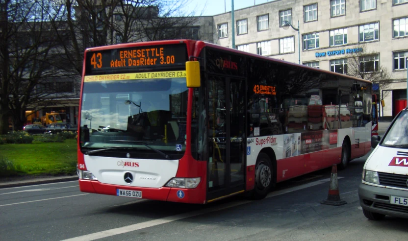 the bus is driving down the street with its door open