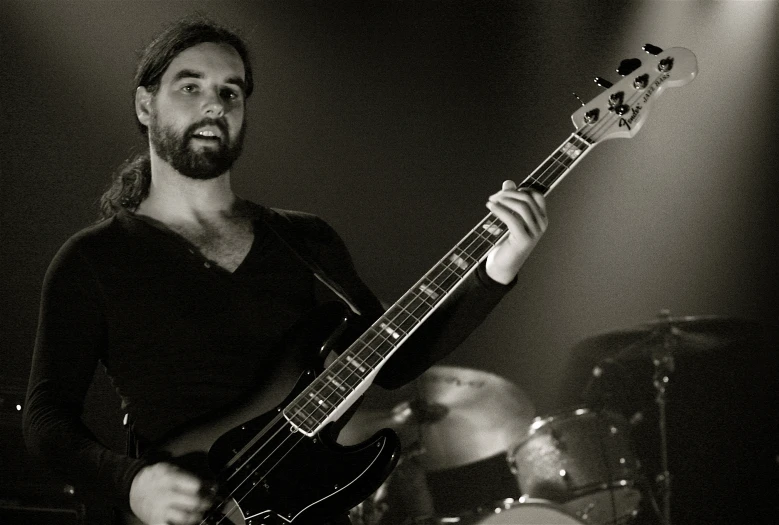 a man holding a guitar and drumming in his hands