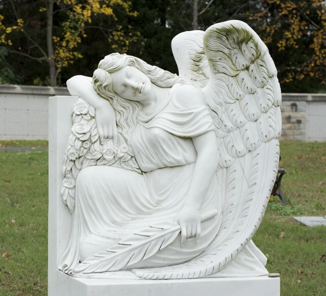 an angel statue is sitting in a cemetery