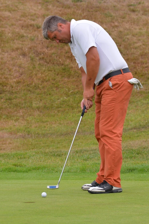 a man playing golf, about to hit the ball