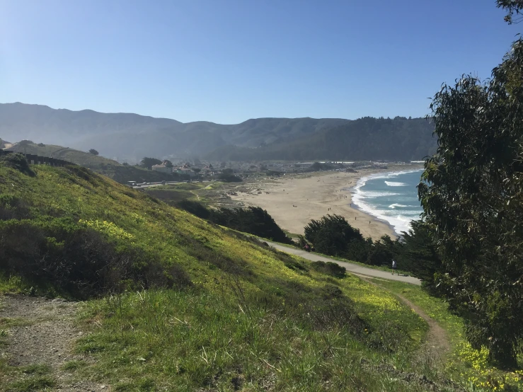 a scenic view of the ocean and coast with hills in the background