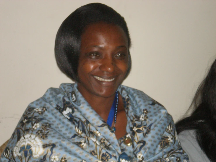 a women wearing a blue flowered shawl and smiling